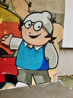 Gesprayte Wandmalerei mit Figur überlebensgroßer Figur Mainzelmännchen, die lächelt und eine Hand ausstreckt
