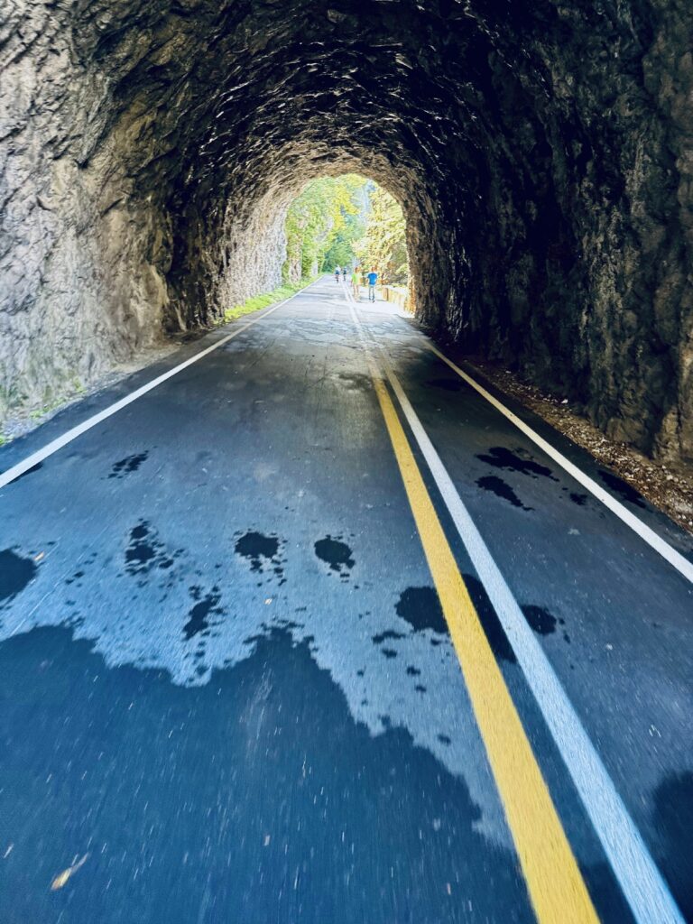 Kleine Straße führt durch runden Tunnel aus Fels