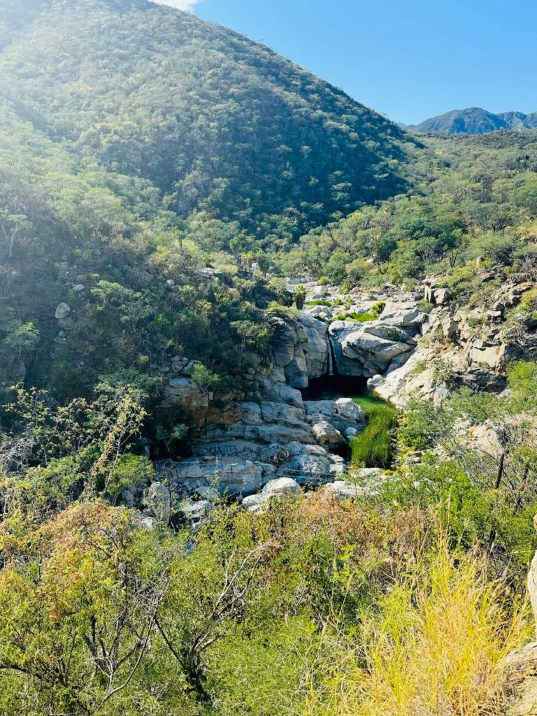 Berglandschaft mit grün bewachsenen Hängen, Felsen Naturpool mit Wasserfall