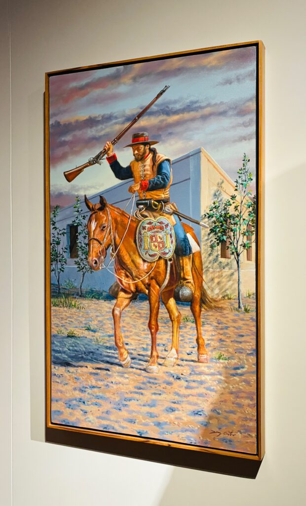 Gemälde eines Reiters in historischer Uniform auf braunem Pferd, der ein Gewehr über dem Kopf hält, vor einem weißen Gebäude und Bäumen