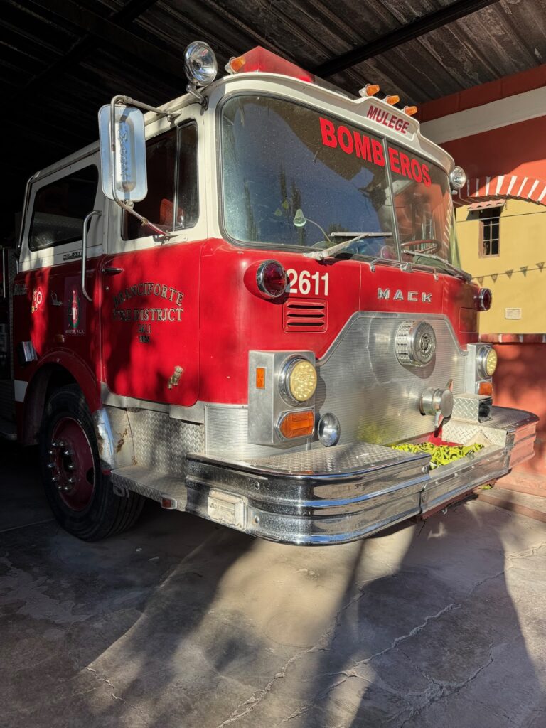 Altmodisches rotes Feuerwehrauto mit der Aufschrift 'BOMBEROS' auf der Frontscheibe