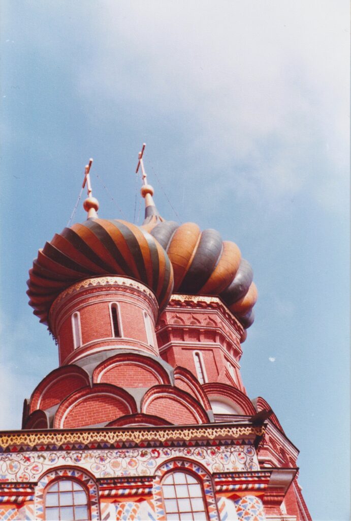 Nahaufnahme der bunten Zwiebeltürme der Basilius-Kathedrale in Moskau vor blauem Himmel. Historische Analogaufnahme