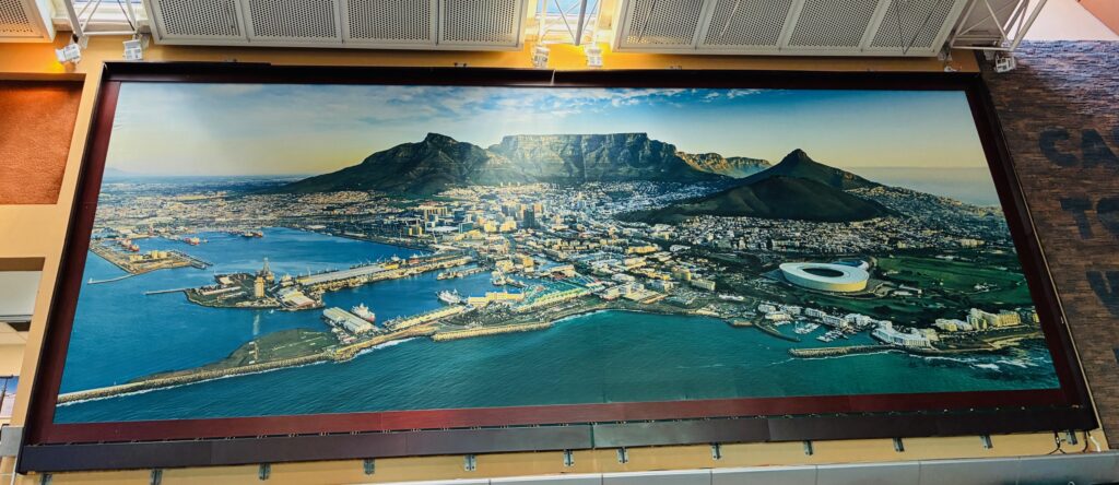 Panoramabild von Kapstadt mit markantem Tafelberg, Hafenanlagen und Stadion im Vordergrund