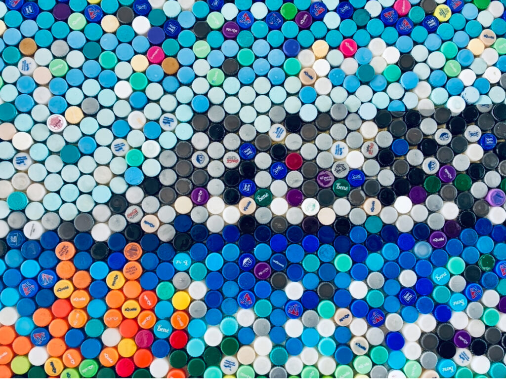 Nahaufnahme eines Mosaiks aus bunten Plastikflaschendeckeln