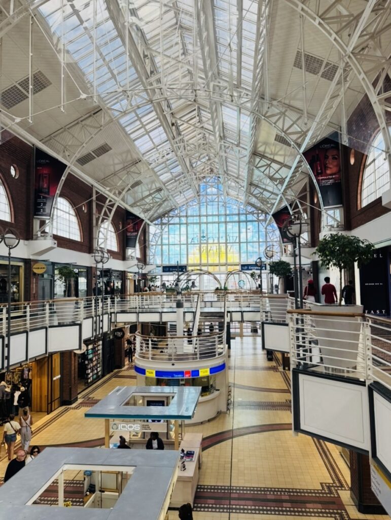 Innenansicht einer Shopping Mall mit offenen Etagen und sichtbaren, weißen Metallstreben