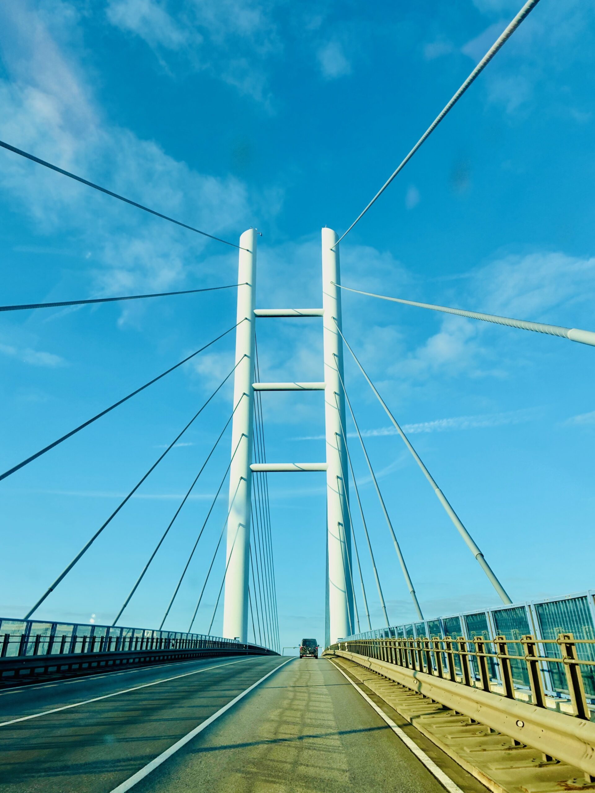 Blick auf eine Hängebrücke mit zwei hohen Pylonen und Fahrbahn unter blauem Himmel