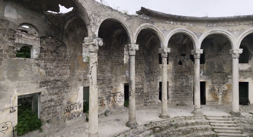 Verfallene Ruine mit neogriechischen Säulen mit halbkreisförmigem Säulengang und Graffiti an den Steinmauern