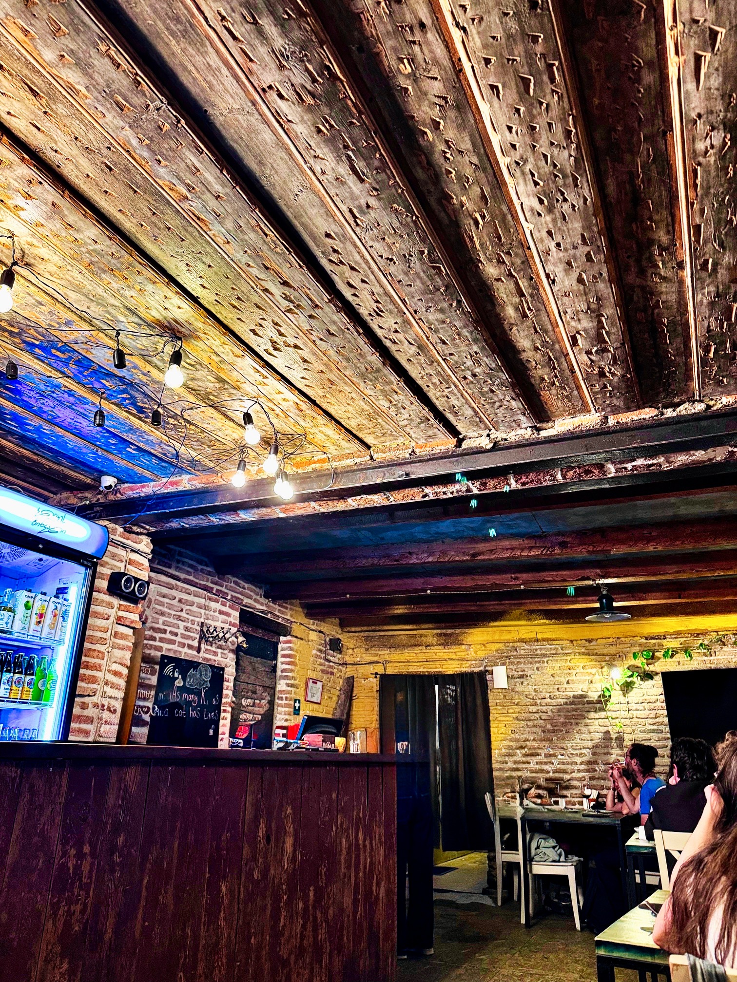 Restaurant mit grober Holzdecke und unverputzten Wänden
