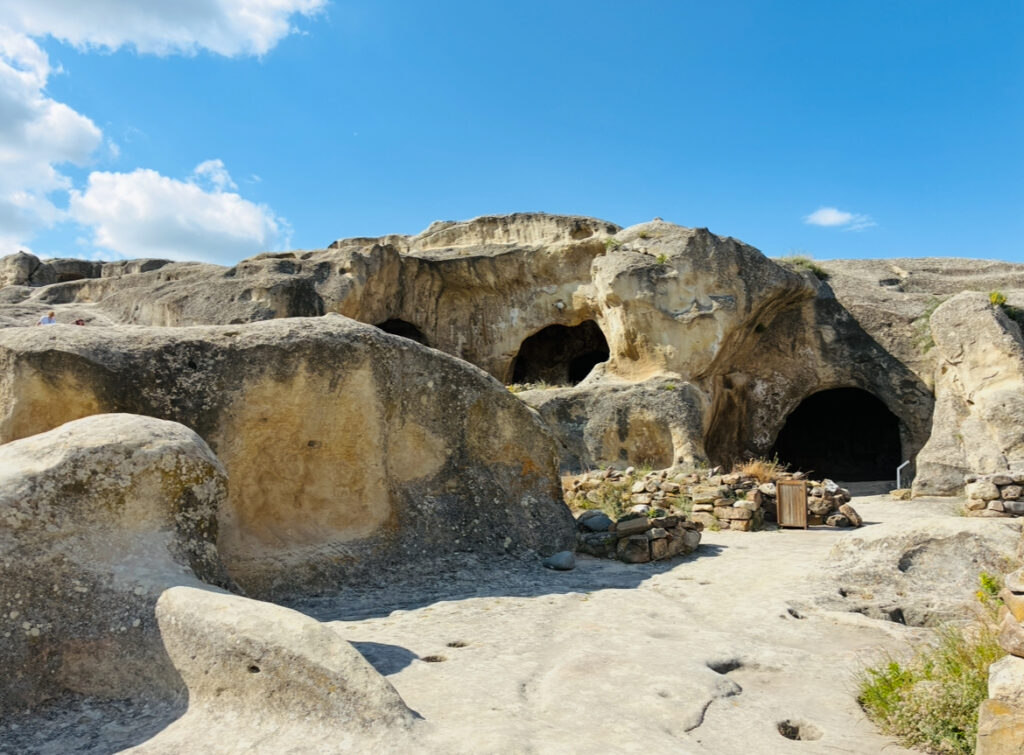 Felsformation mit mehreren natürlichen Höhleneingängen unter blauem Himmel