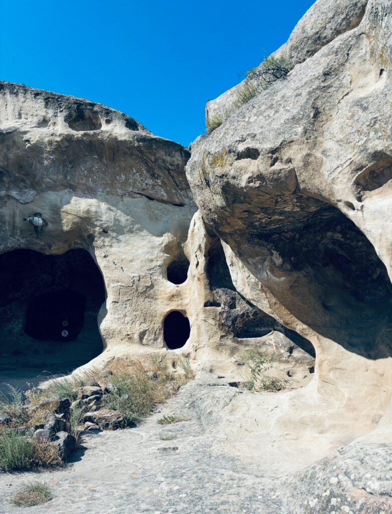 Felsformation mit mehreren natürlichen Höhlenöffnungen unter blauem Himmel