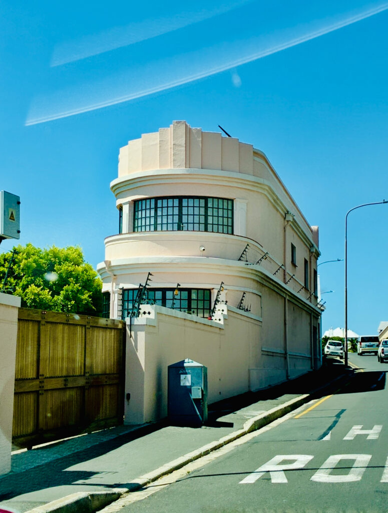 Kleines Jugendstilgebäude an einer Straße unter blauem Himmel