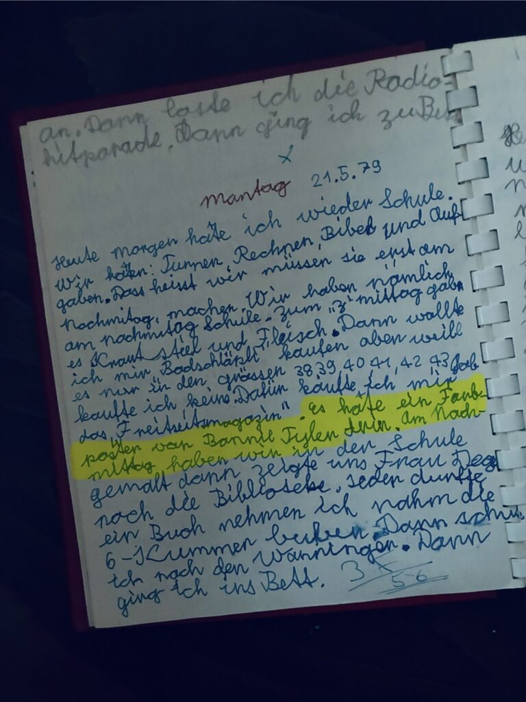 Handschriftliche Tagebuchseite mit blauem und schwarzem Text in krakeliger Kinderschrift und hervorgehobener gelber Markierung "Es hatte ein Foto von Bonnie Tyler drin", und Datum '21.5.79'