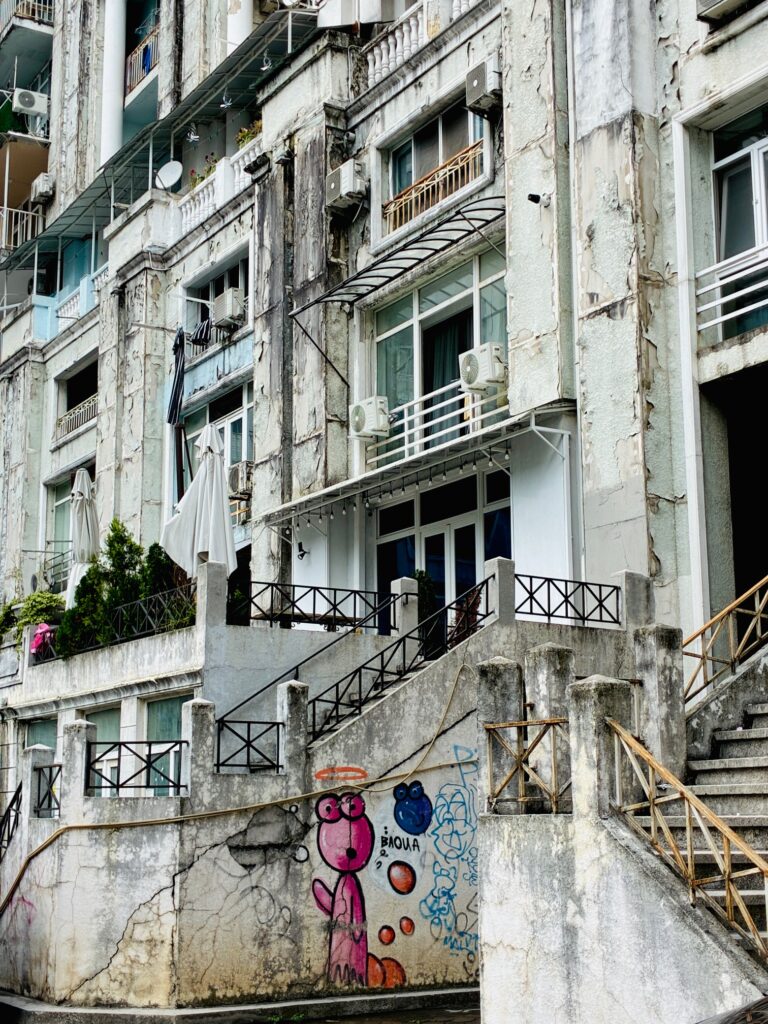 Fassade eines maroden Wohnhauses mit Graffiti und mehreren Klimaanlagen an den Fenstern
