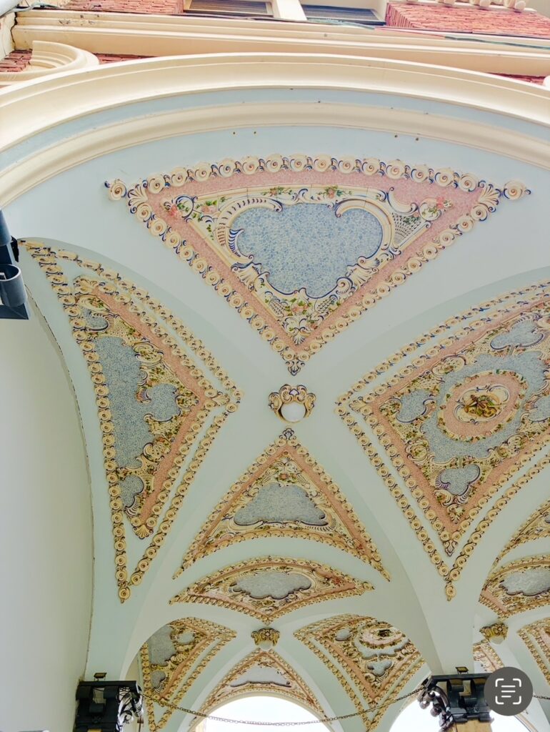 Gewölbte Decke mit dreieckigen, ornamental verzierten Feldern und goldfarbenen Details in einer historischen Toreinfahrt