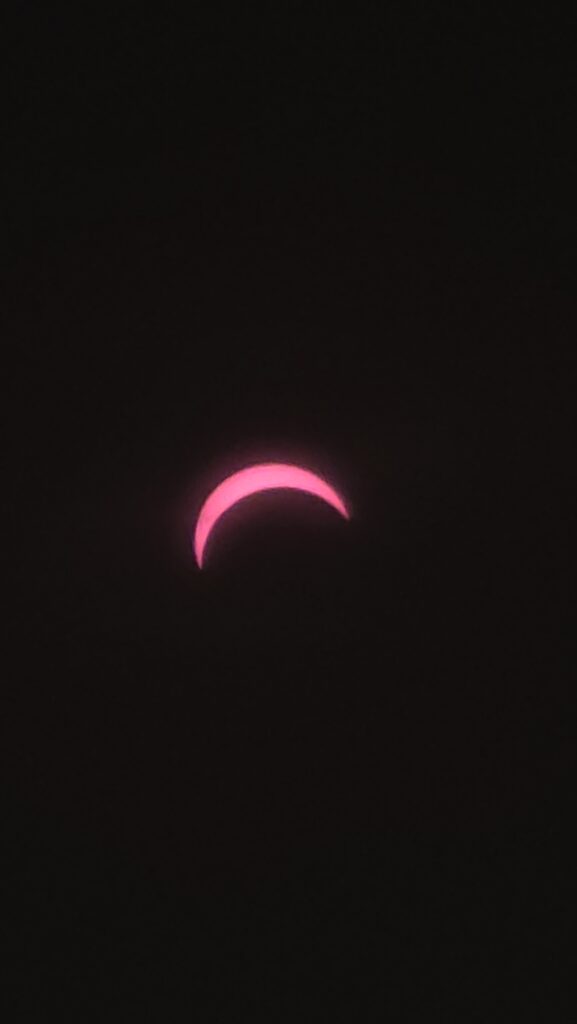 Sonnenfinsternis in Berlin im August 2026: Rosa sichelförmiger Lichtbogen vor schwarzem Hintergrund